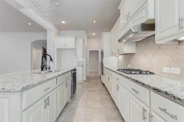 a kitchen with stainless steel appliances granite countertop a sink and a stove