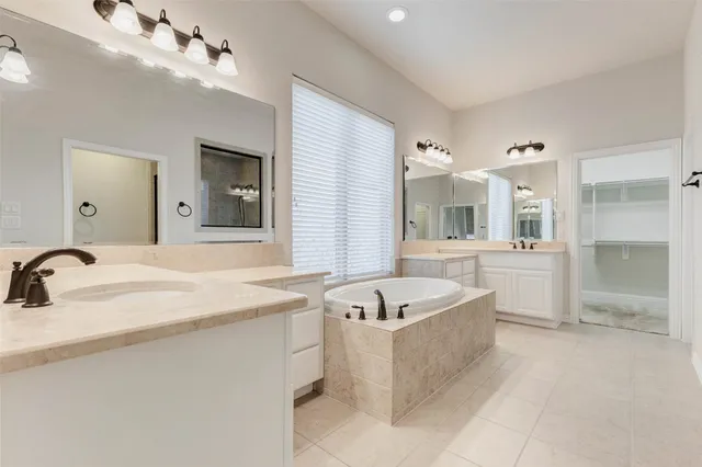 a spacious bathroom with a bathtub sink and mirror