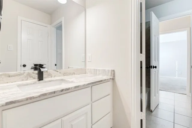a bathroom with a granite countertop sink and a mirror