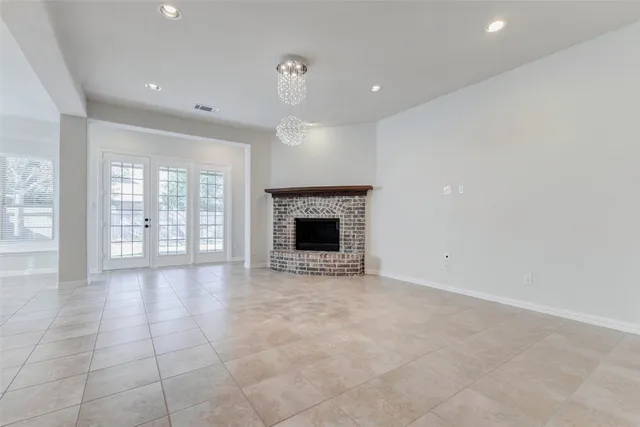 an empty room with fireplace and windows