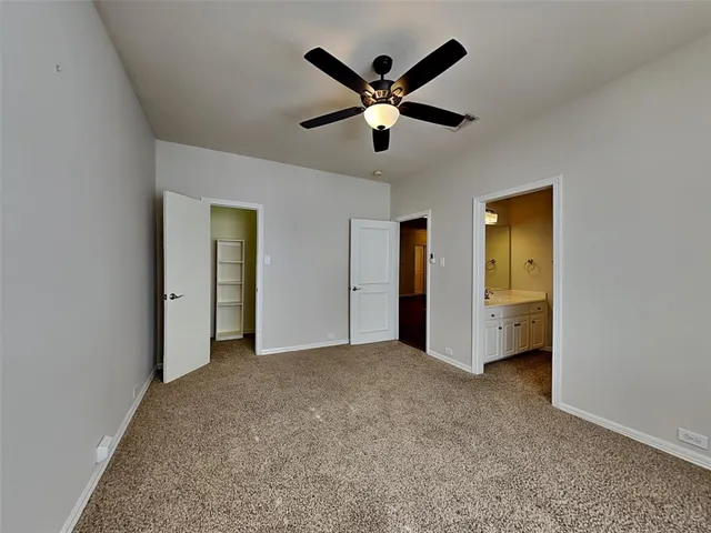 a view of an empty room with a ceiling fan