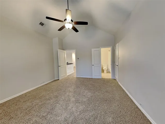 a view of an empty room and a chandelier fan