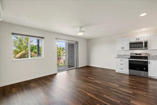 a large white kitchen with a sink a stove and refrigerator