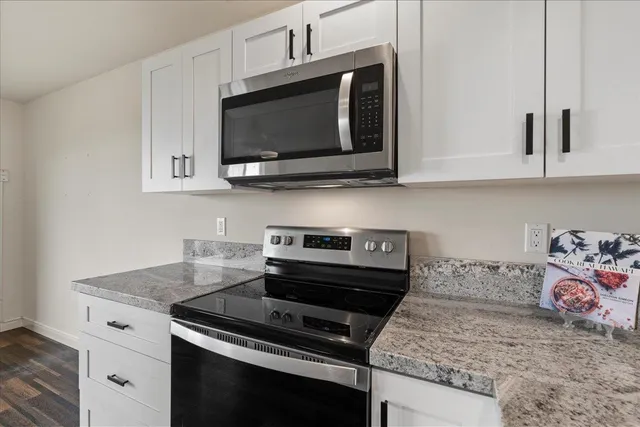 a kitchen with stainless steel appliances granite countertop a sink a stove and microwave