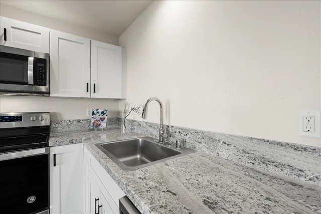 a kitchen with stainless steel appliances granite countertop a sink and a stove