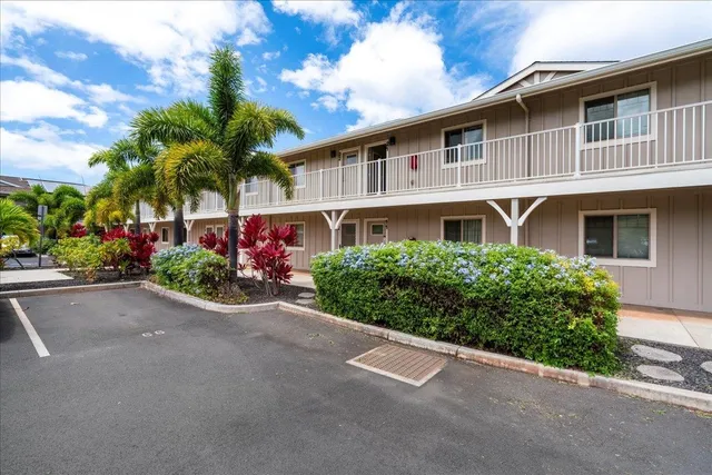 a front view of a house with cars parked