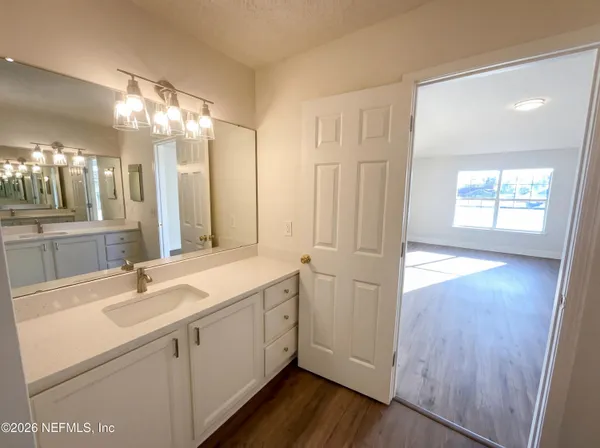 a bathroom with a double vanity sink and mirror with shower