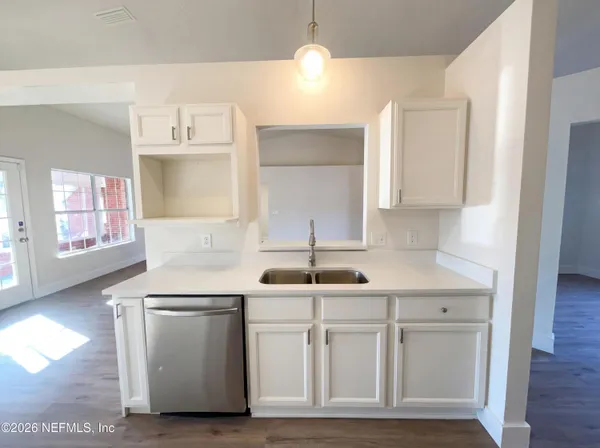 a kitchen with a sink cabinets and wooden floor