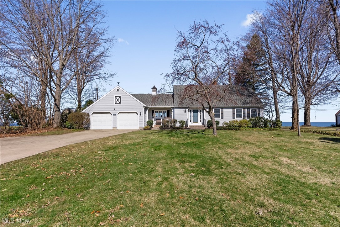 1122 Lake Road Conneaut, OH 44030 - Photo 1 of 50 View of front of home featuring a chimney, a front yard, driveway, and an attached garage