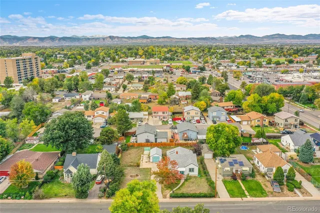 an aerial view of residential houses with outdoor space and ocean view