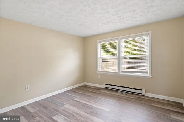 a view of a room with wooden floor and a window