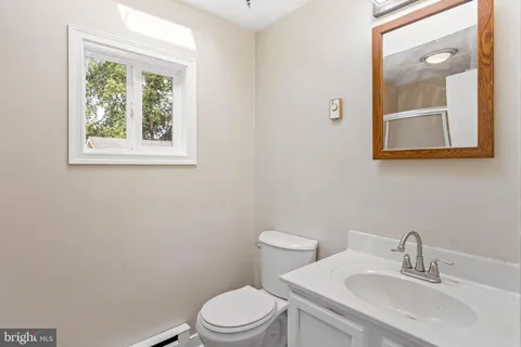 a bathroom with a toilet a sink and a mirror