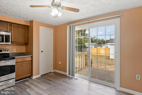 a view of a kitchen with wooden floor and a ceiling fan