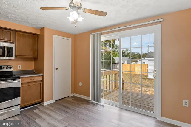 a view of a kitchen with wooden floor and a ceiling fan