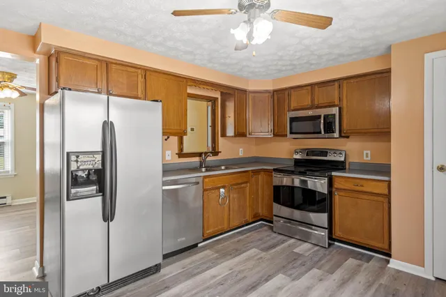 a kitchen with stainless steel appliances granite countertop a refrigerator a stove top oven a sink and dishwasher