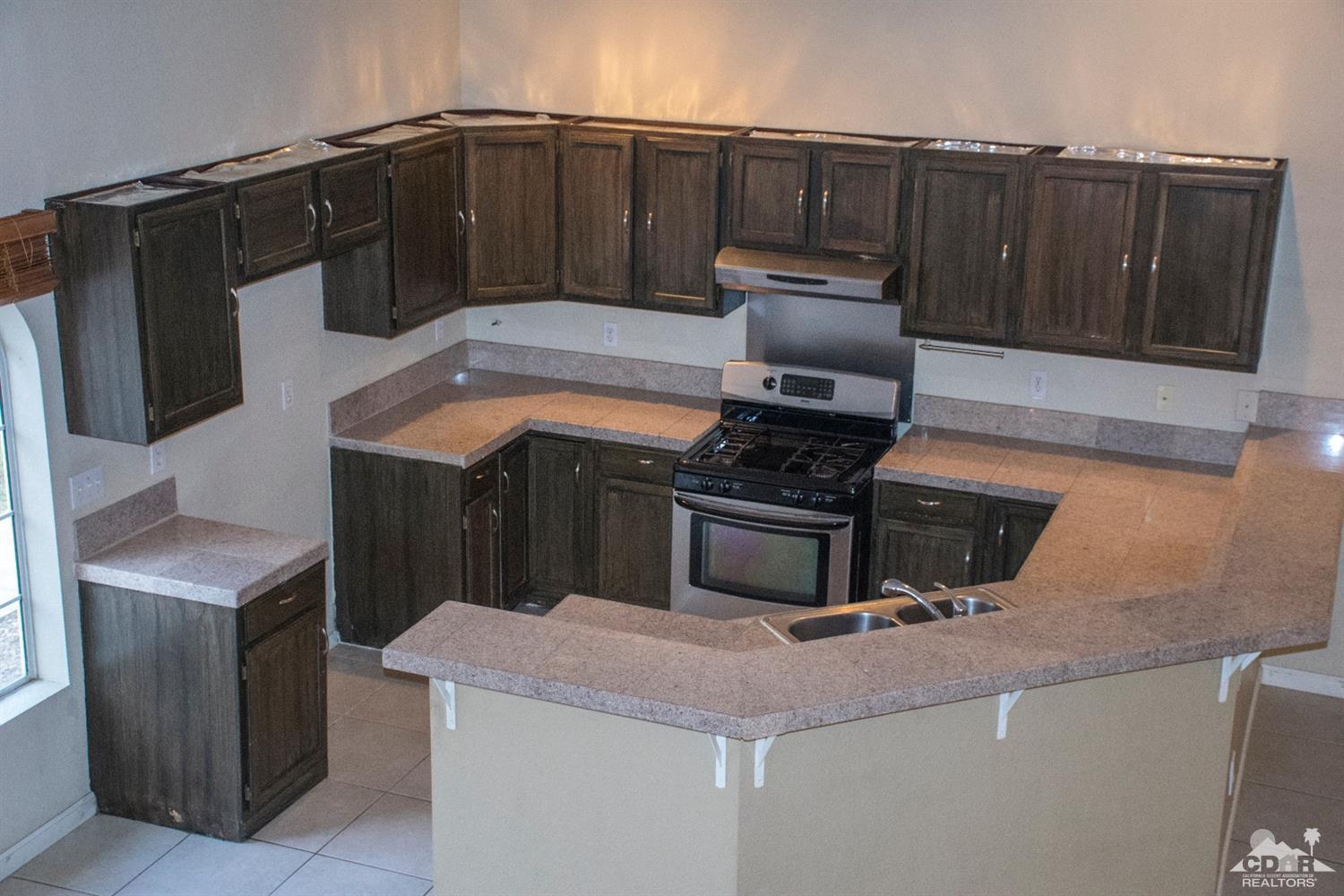 68340 Tortuga Road Cathedral City, CA 92234 - Photo 12 of 37 a kitchen with granite countertop a stove and a microwave