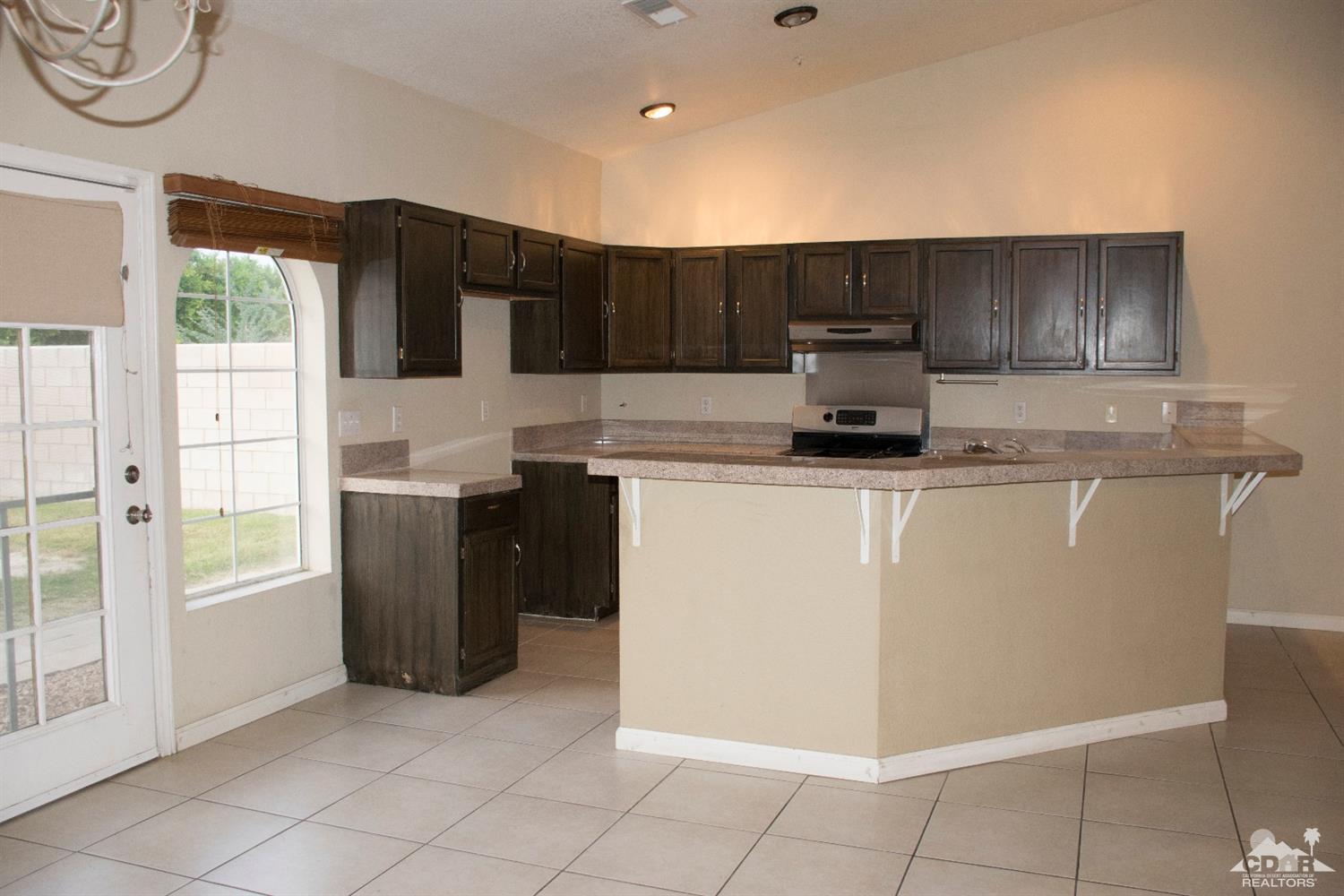 68340 Tortuga Road Cathedral City, CA 92234 - Photo 13 of 37 a kitchen with a sink a stove top oven and cabinets