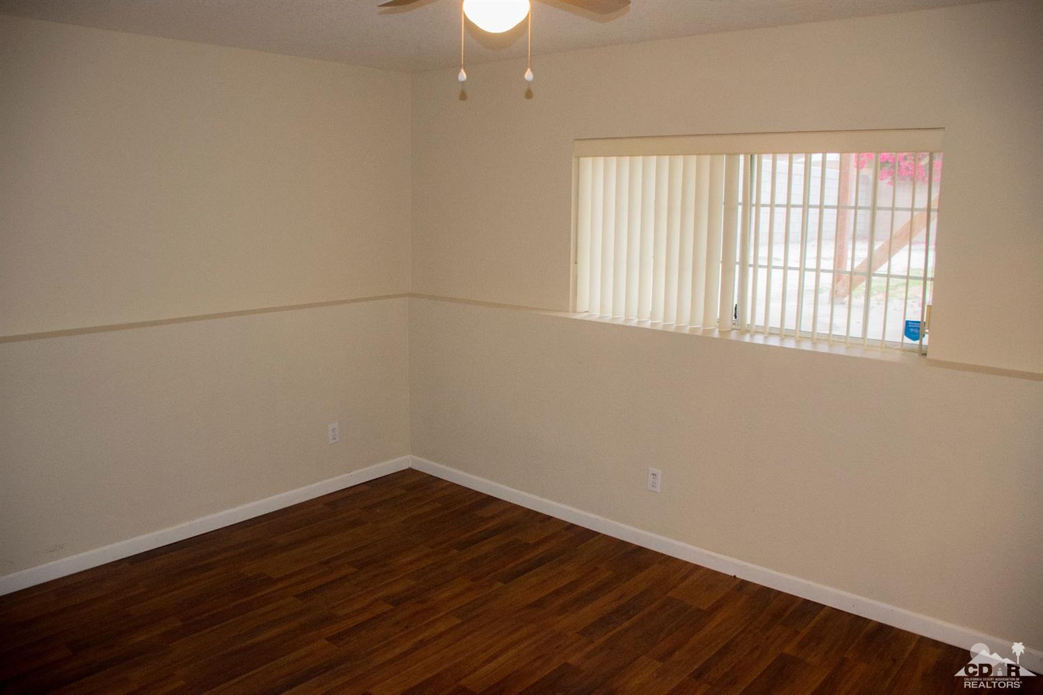 68340 Tortuga Road Cathedral City, CA 92234 - Photo 15 of 37 wooden floor in an empty room with a window