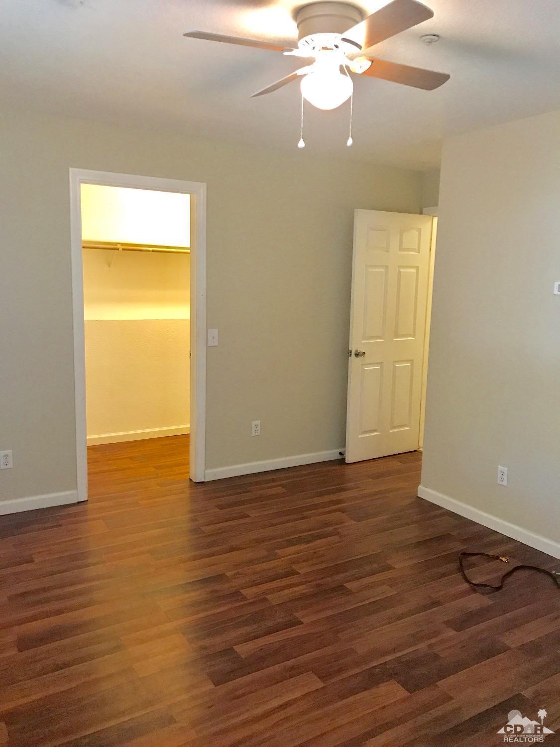 68340 Tortuga Road Cathedral City, CA 92234 - Photo 16 of 37 a view of an empty room with wooden floor and a window
