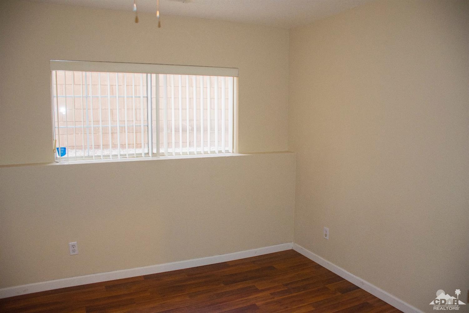 68340 Tortuga Road Cathedral City, CA 92234 - Photo 17 of 37 an empty room with wooden floor and windows