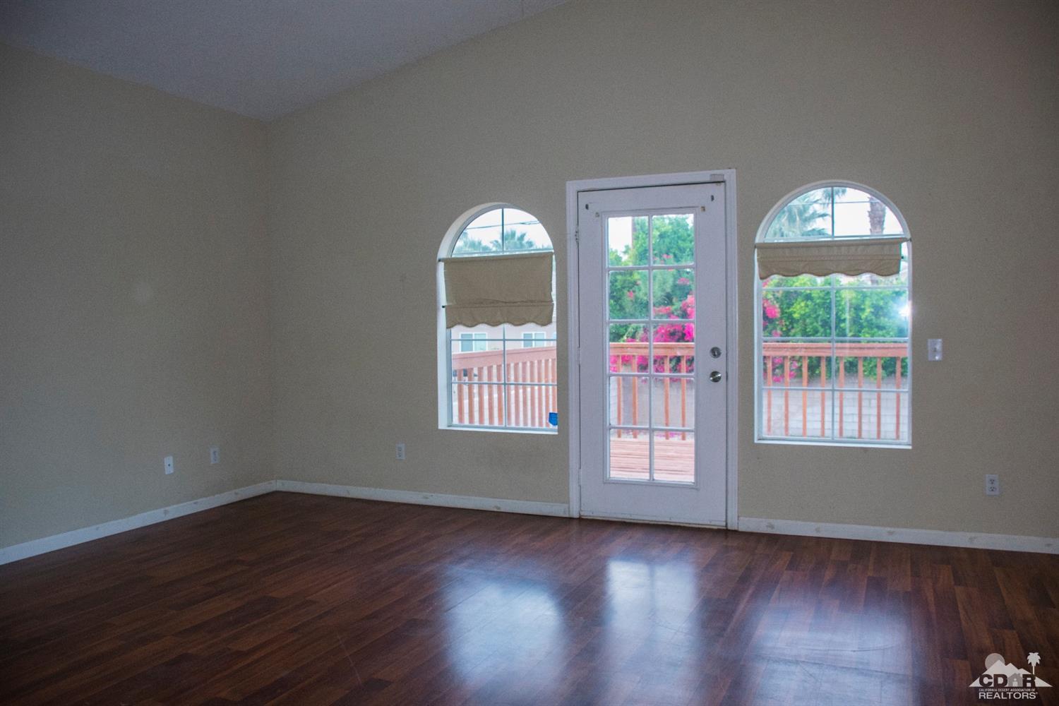 68340 Tortuga Road Cathedral City, CA 92234 - Photo 22 of 37 an empty room with wooden floor and windows