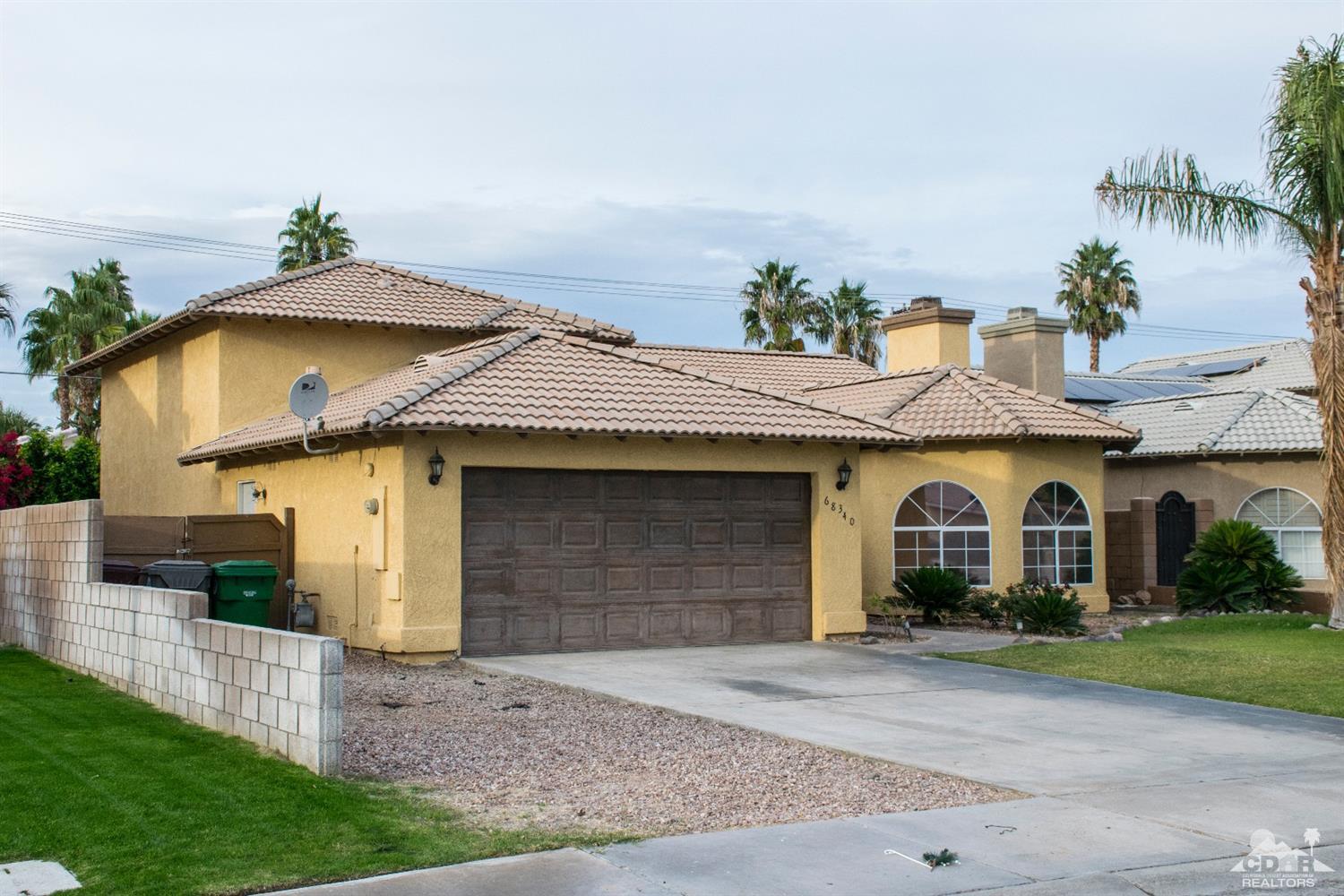 68340 Tortuga Road Cathedral City, CA 92234 - Photo 4 of 37 a front view of a house with a yard and garage