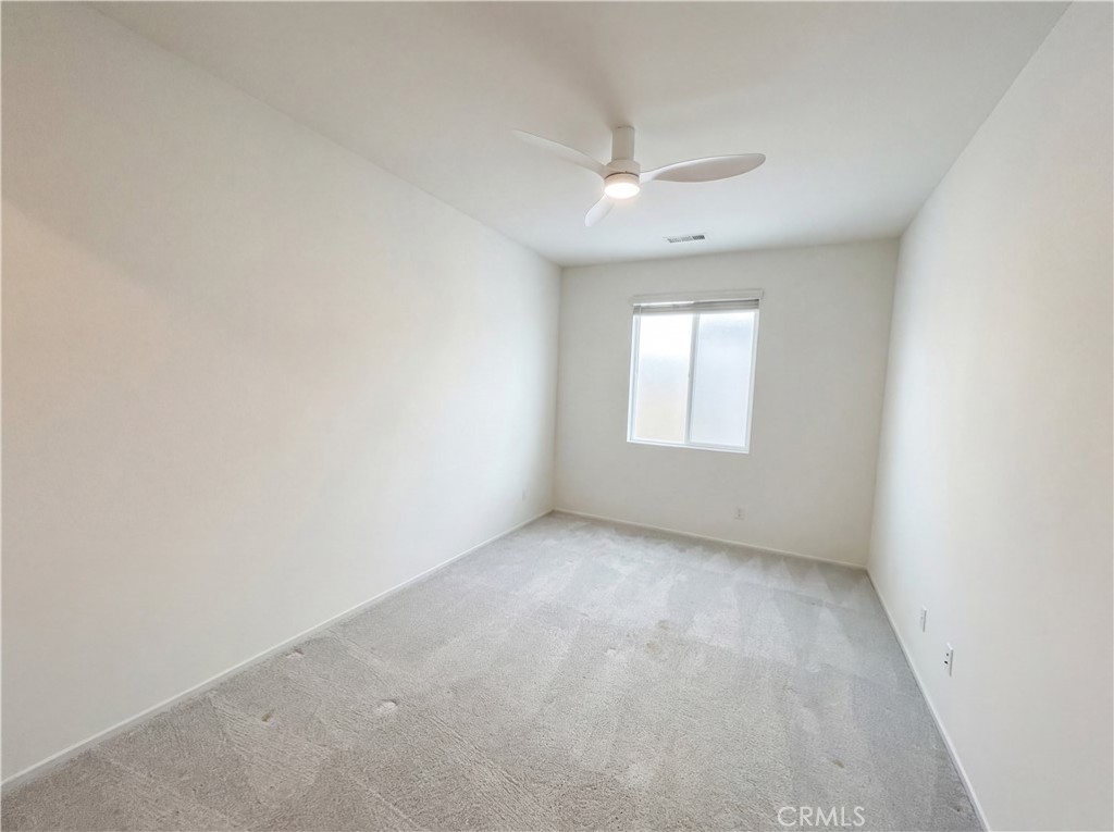 5628 Kate Way, Unit 3 Fontana, CA 92336 - Photo 12 of 20 an empty room with a window and ceiling fan
