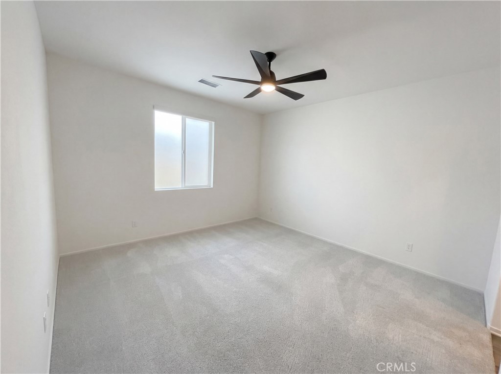 5628 Kate Way, Unit 3 Fontana, CA 92336 - Photo 15 of 20 an empty room with a window and a fan