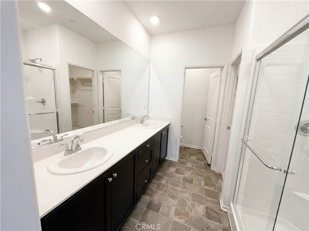 5628 Kate Way, Unit 3 Fontana, CA 92336 - Photo 16 of 20 a spacious bathroom with double vanity and mirrors