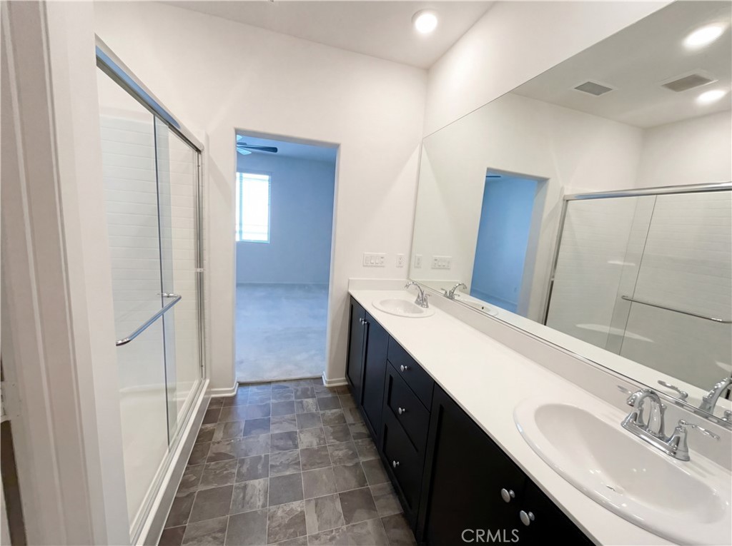 5628 Kate Way, Unit 3 Fontana, CA 92336 - Photo 19 of 20 a bathroom with a double vanity sink and mirror