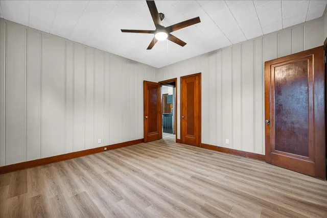 an empty room with closet and a ceiling fan