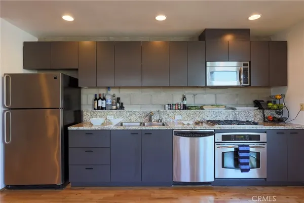 a kitchen with a sink a refrigerator and a stove top oven