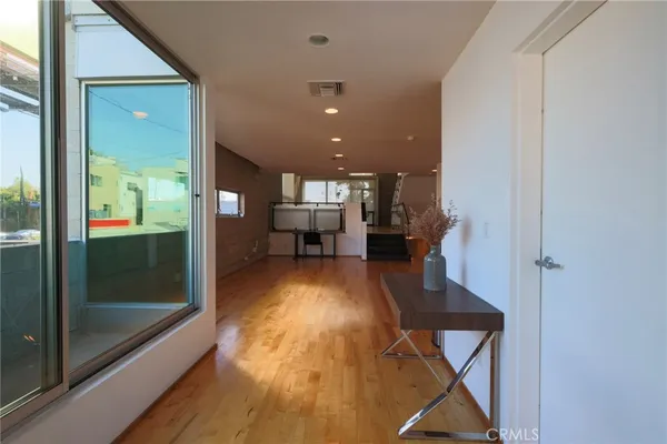 a view of a hallway with wooden floor windows and chairs