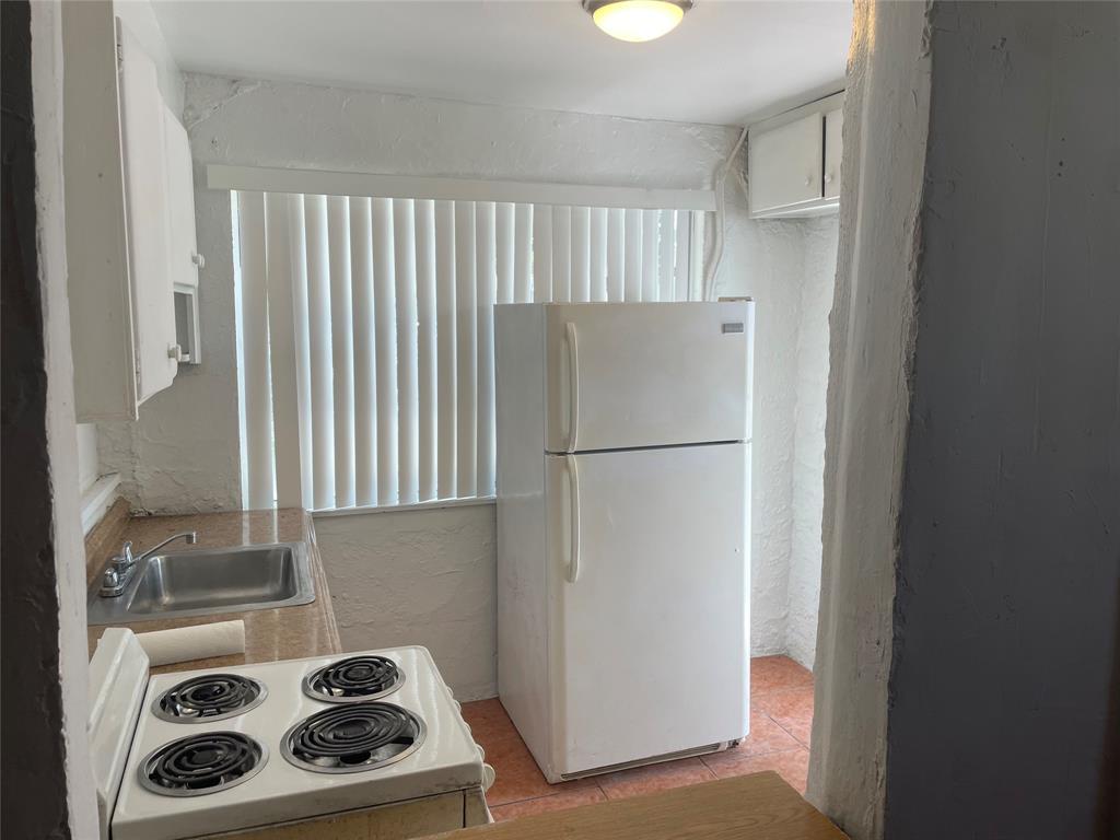 36 Southwest 14th Street, Unit 2 Dania Beach, FL 33004 - Photo 2 of 6 a kitchen with a refrigerator and a stove