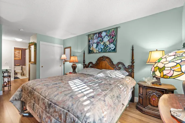 a bedroom with bed and wooden floor