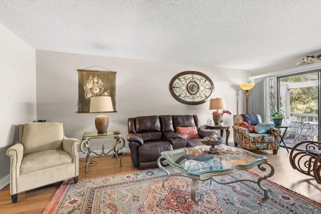 a living room with furniture a clock on wall and a window