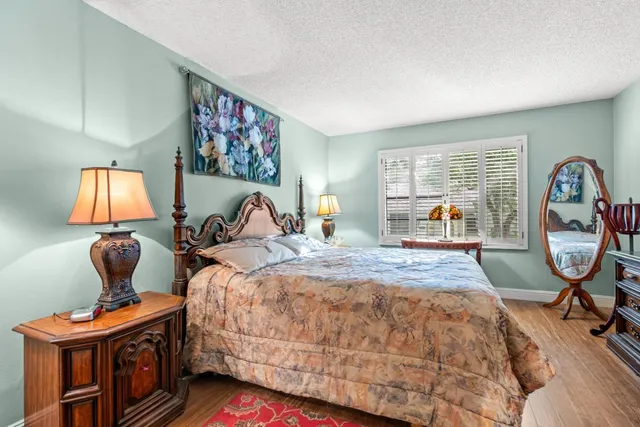 a bedroom with bed and wooden floor