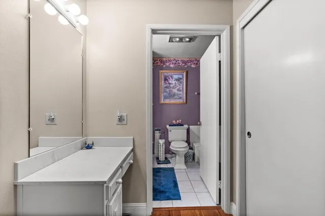 a bathroom with a sink a toilet and a mirror