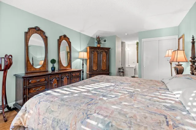 a bedroom with a bed and dresser with mirror