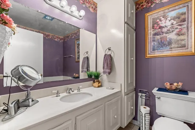 a bathroom with a granite countertop sink a toilet and a mirror