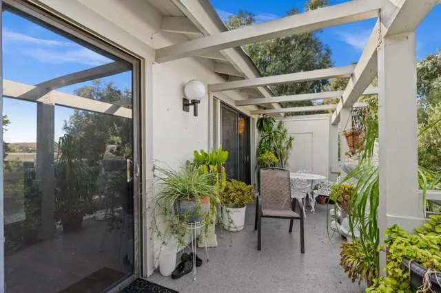 a view of a porch with chairs and potted plants