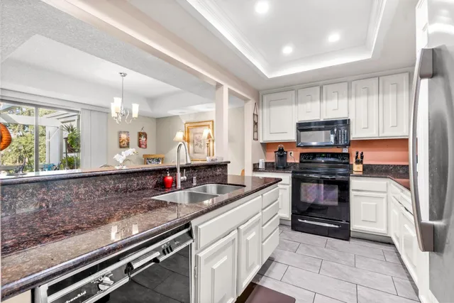 a kitchen with stainless steel appliances kitchen island granite countertop a stove sink and microwave