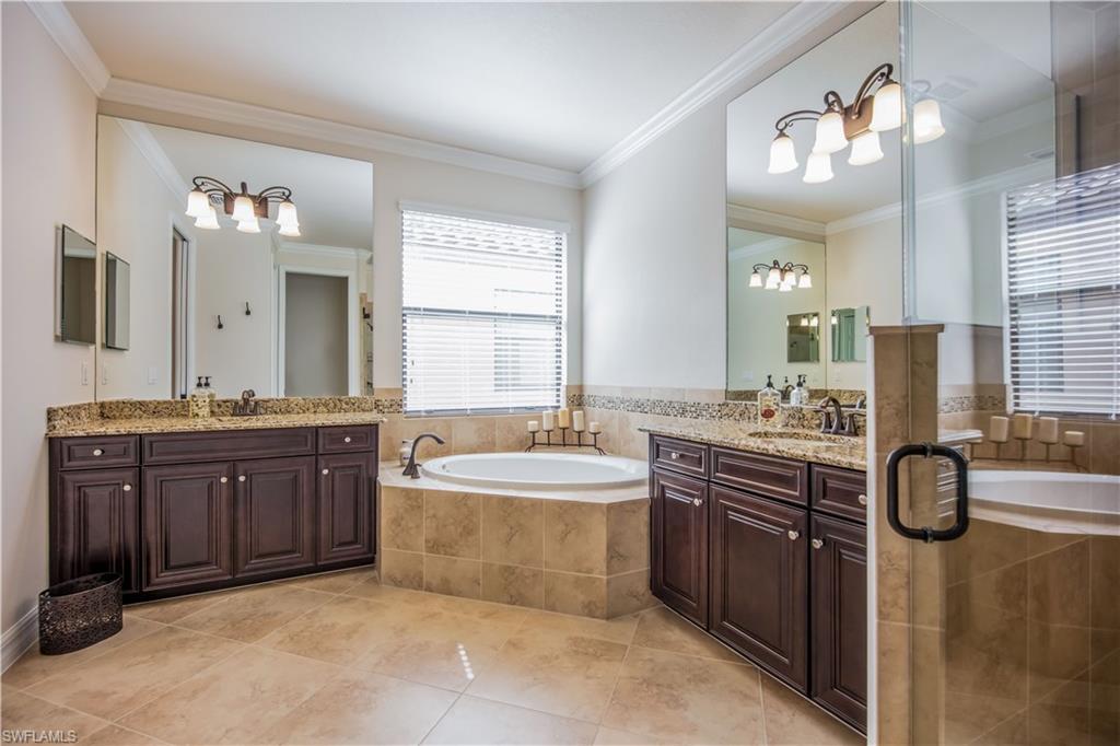9422 Piacere Way Naples, FL 34113 - Photo 9 of 25 Large master bathroom with dual sinks, jetted tub, and a walk-in shower