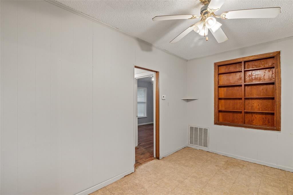 302 West Grogan Street Hamilton, TX 76531 - Photo 14 of 33 Empty room featuring visible vents, a ceiling fan, and a textured ceiling