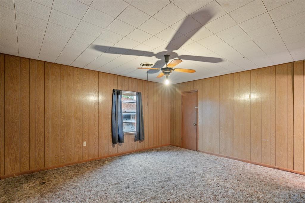 302 West Grogan Street Hamilton, TX 76531 - Photo 21 of 33 Carpeted empty room with wooden walls and ceiling fan
