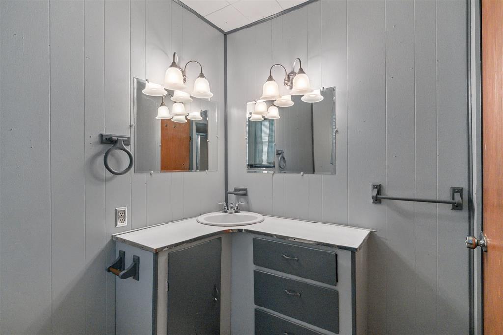 302 West Grogan Street Hamilton, TX 76531 - Photo 25 of 33 Bathroom with vanity and a decorative wall
