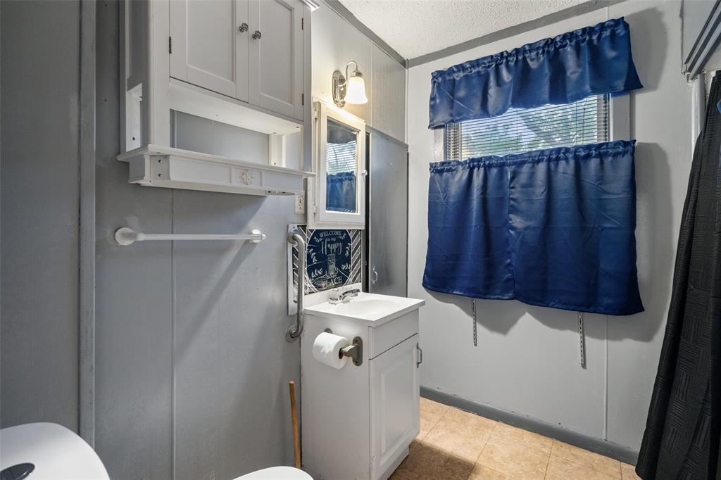 302 West Grogan Street Hamilton, TX 76531 - Photo 28 of 33 Half bathroom featuring vanity, tile patterned flooring, and toilet
