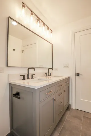 a bathroom with a double vanity sink and mirror