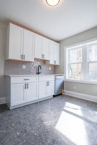 a kitchen with white cabinets and white appliances