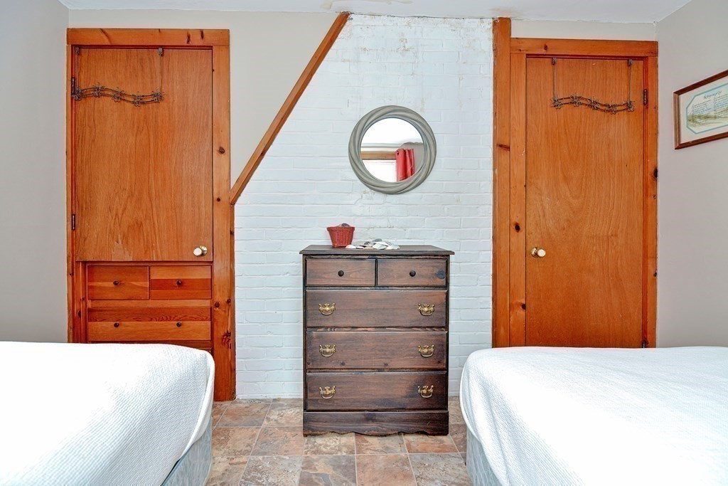 27 Naushon Road Dennis, MA 02639 - Photo 13 of 31 a bedroom with a bed and wooden cabinets